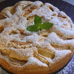 Szybkie tanie ciasto z jabłkami, posypane cukrem pudrem i ozdobione listkiem mięty. Idealne na deser.