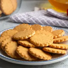 Stos pysznych, szybkich ciasteczek maślanych na talerzu z niebieskim wzorem. Idealne na podwieczorek.