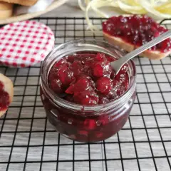 Domowy konfitura z żurawiny przepis. Słoiczek pełen pyszności, obok kromki chleba z żurawiną.