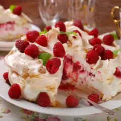 Beza z mascarpone i malinami, udekorowana świeżymi owocami i miętą.