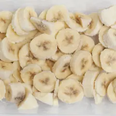 Pokrojone w plasterki banany w pojemniku, gotowe do mrożenia. To dowód, że banany można mrozić, idealne do smoothie!