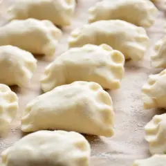 Rządki surowego, tradycyjnego ciasta na pierogi, gotowe do nadziewania.