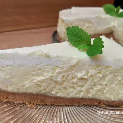 Pyszny sernik z wiaderka z budyniem, idealny na deser. Kremowa masa na kruchym spodzie, ozdobiony listkiem mięty.