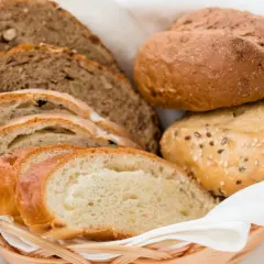 Koszyk z różnymi rodzajami chleba i bułek. Dowiedz się, jak odświeżyć chleb, by znów był pyszny.