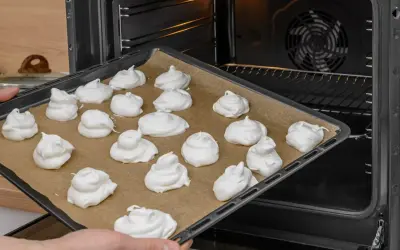 Taca z bezami gotowa do pieczenia. Idealna temperatura pieca bezy to klucz do ich chrupkości.