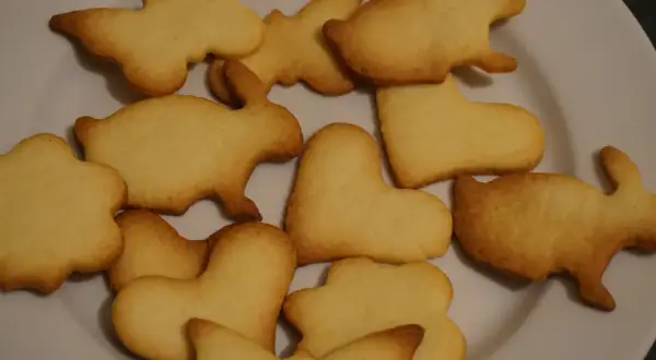Na talerzu ułożone są **szybkie kruche ciasteczka** w kształcie króliczków, motylków i serduszek.