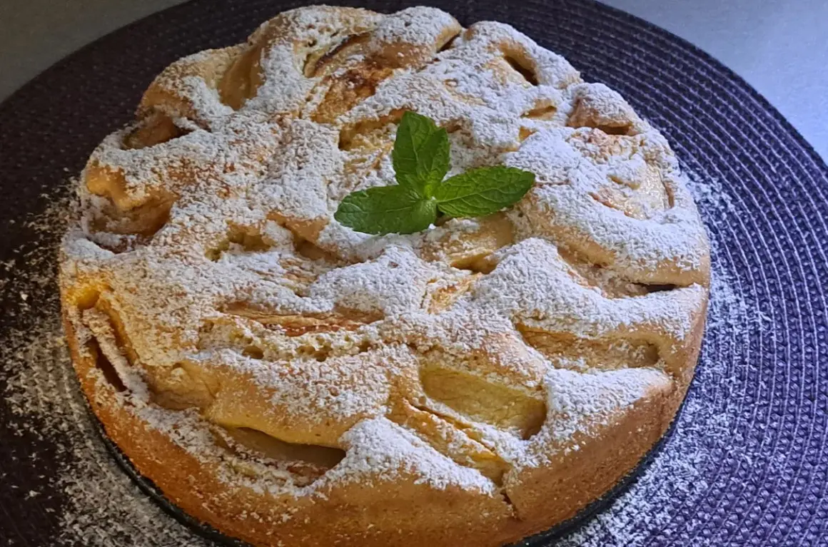Szybkie tanie ciasto z jabłkami, posypane cukrem pudrem i ozdobione listkiem mięty. Idealne na deser.
